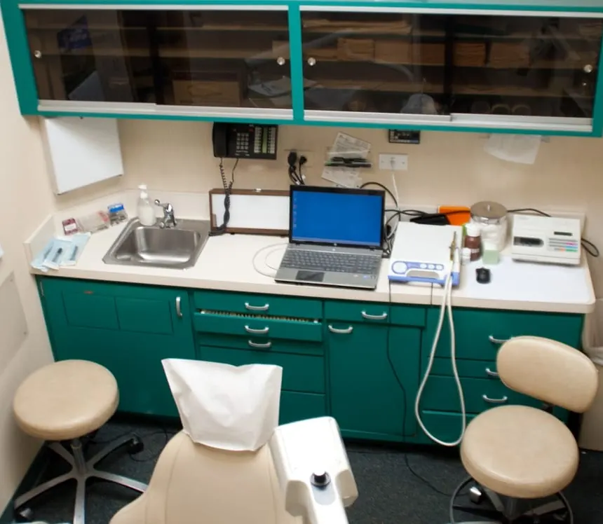 A hygiene room at North Shore Dental with a laptop and instruments on the counter.